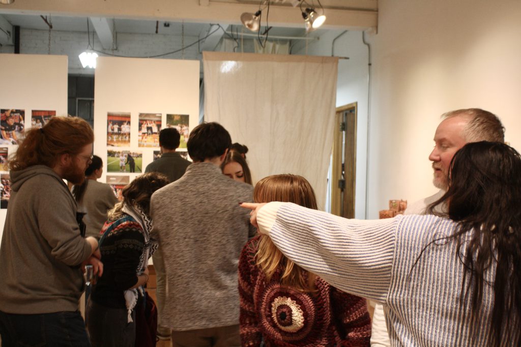 Unnamed student points man in direction of open gallery space