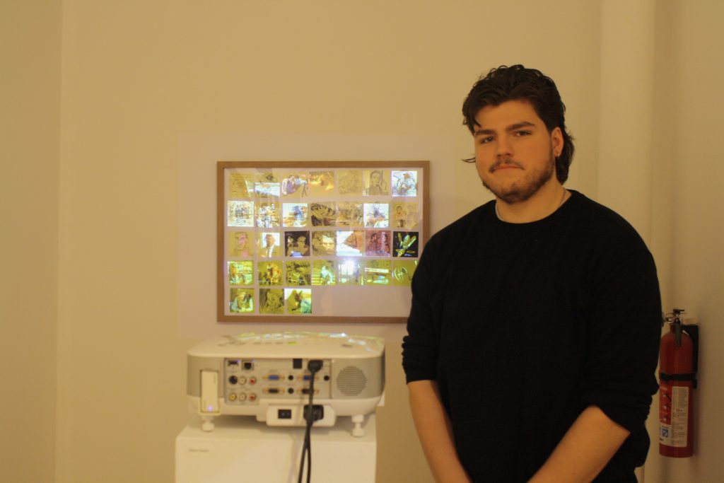 Student (James Hauke) stands next to multiple pictures projected on to a frame which overlap various
illustrations